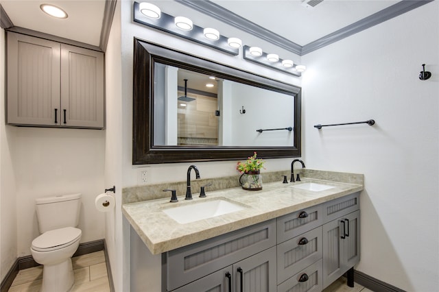 full bath with toilet, double vanity, ornamental molding, and a sink