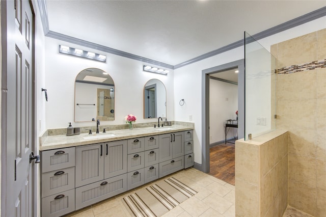 full bath with ornamental molding, double vanity, a sink, and tile patterned floors