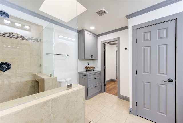 bathroom with visible vents, baseboards, tiled shower, tile patterned floors, and crown molding