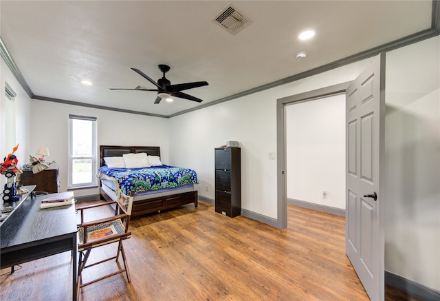 bedroom featuring crown molding, visible vents, light wood-style flooring, ceiling fan, and baseboards