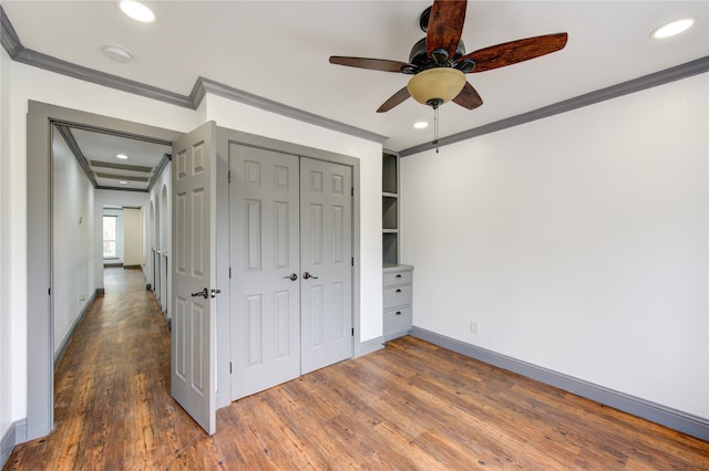 unfurnished bedroom featuring baseboards, recessed lighting, wood finished floors, and crown molding