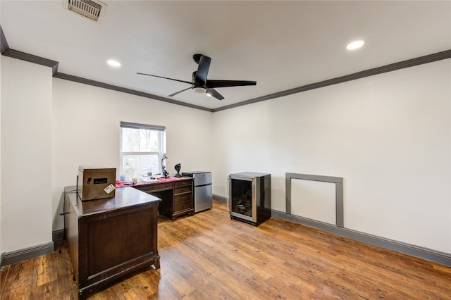 home office with a ceiling fan, beverage cooler, visible vents, and wood finished floors