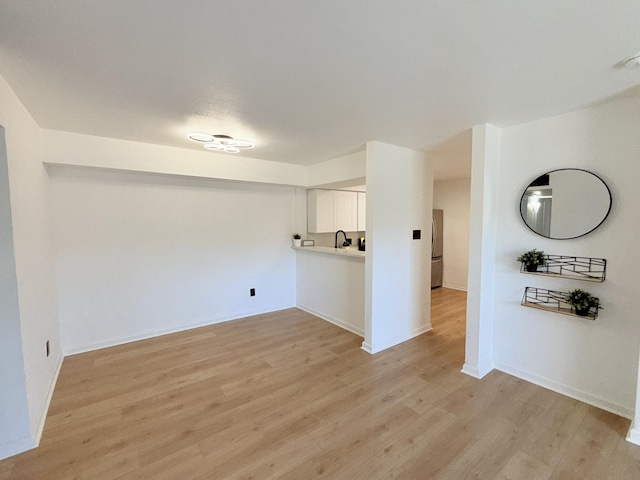 washroom featuring light wood-style flooring and baseboards