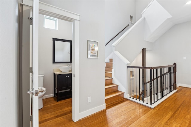 staircase with baseboards and wood finished floors