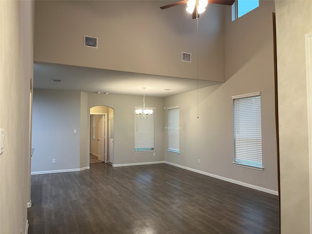 spare room featuring visible vents, dark wood finished floors, baseboards, and ceiling fan with notable chandelier