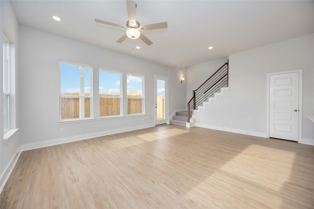 unfurnished living room with recessed lighting, a ceiling fan, baseboards, light wood-style floors, and stairway