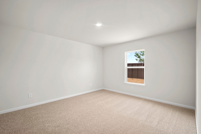 empty room with baseboards, recessed lighting, and light colored carpet