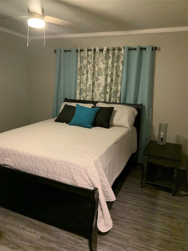 bedroom featuring ornamental molding, wood finished floors, and a ceiling fan