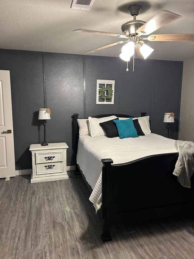 bedroom with visible vents, a ceiling fan, and wood finished floors