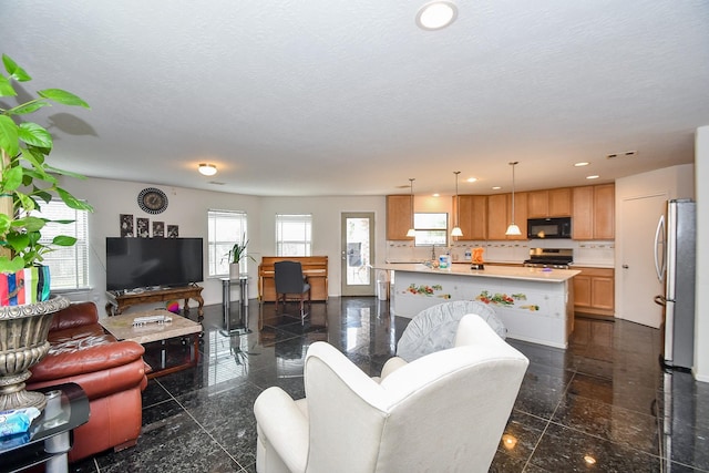 living area with a textured ceiling, granite finish floor, baseboards, and recessed lighting