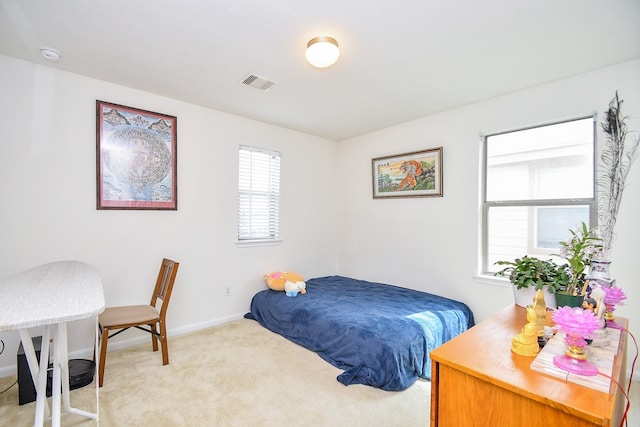 bedroom with light colored carpet, visible vents, and baseboards