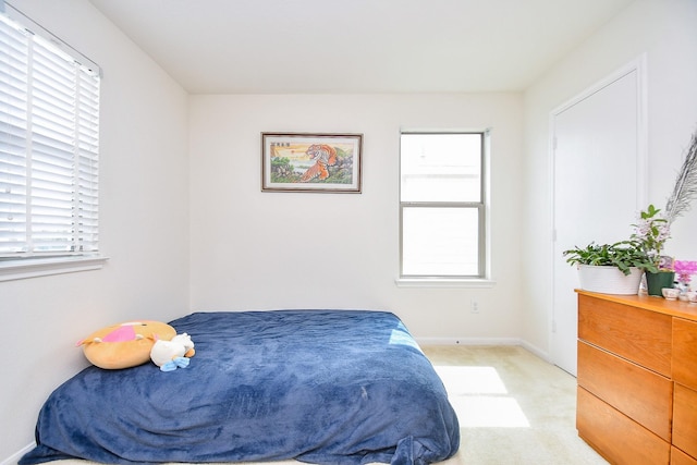 bedroom with light carpet and baseboards