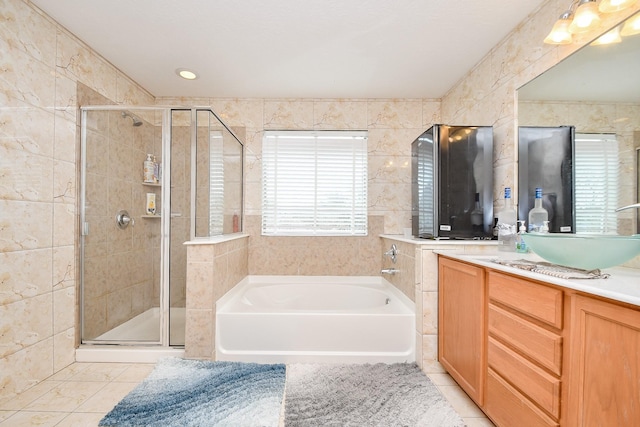 bathroom with a stall shower, vanity, a garden tub, and tile patterned floors