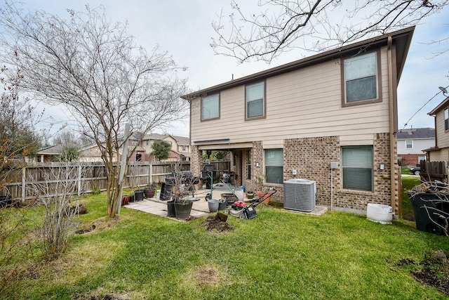 back of property with a patio, central AC, brick siding, fence, and a yard