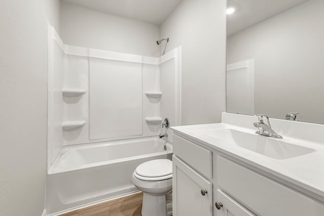 full bath featuring washtub / shower combination, toilet, wood finished floors, and vanity