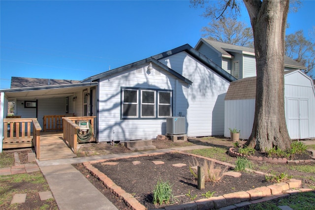 view of front of property featuring a porch, an outbuilding, a shed, and central AC unit