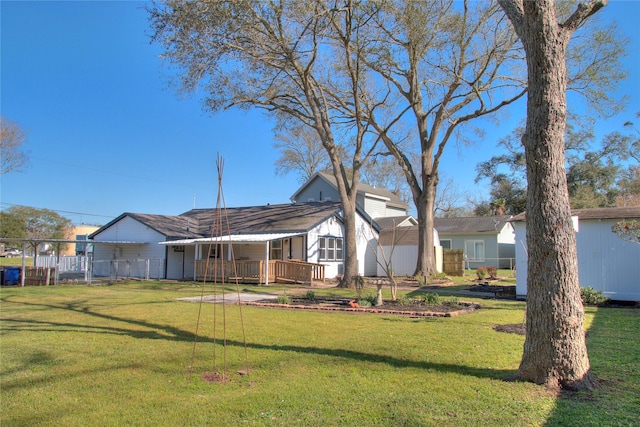 rear view of property with a lawn and fence