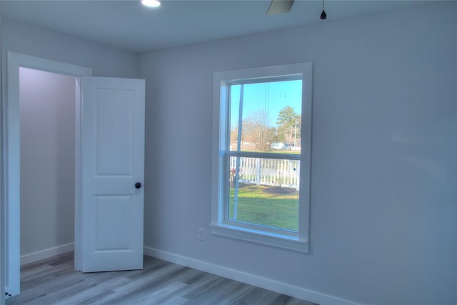 spare room featuring light wood-type flooring, baseboards, and recessed lighting