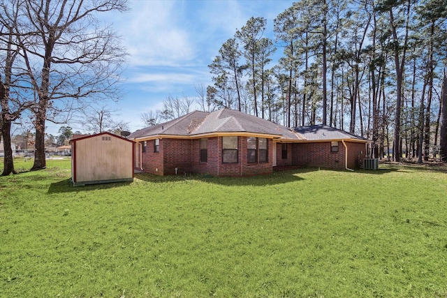 back of property with central air condition unit, brick siding, an outdoor structure, a lawn, and a storage unit