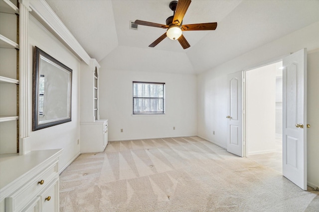 unfurnished room with visible vents, vaulted ceiling, a ceiling fan, and light colored carpet