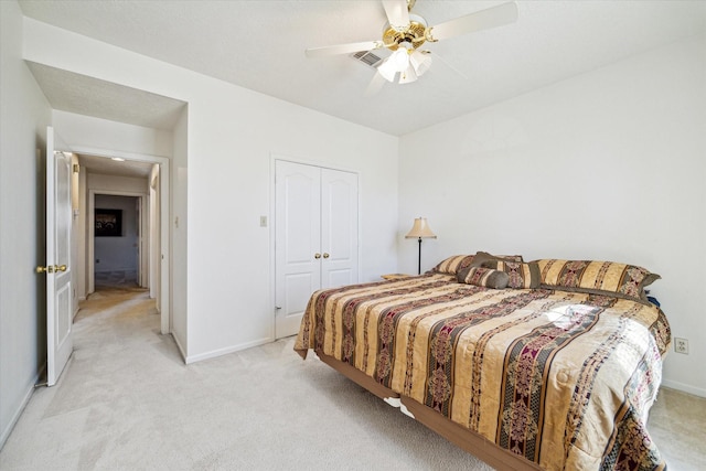 bedroom featuring a closet, light colored carpet, and baseboards