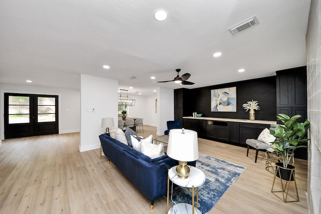 living area with recessed lighting, visible vents, a wealth of natural light, and light wood finished floors
