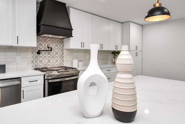 kitchen featuring light countertops, white cabinetry, tasteful backsplash, custom range hood, and stainless steel appliances