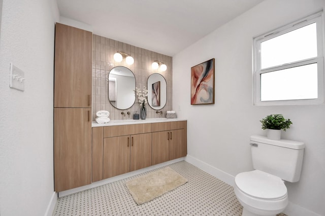 bathroom with toilet, baseboards, tile patterned floors, and vanity