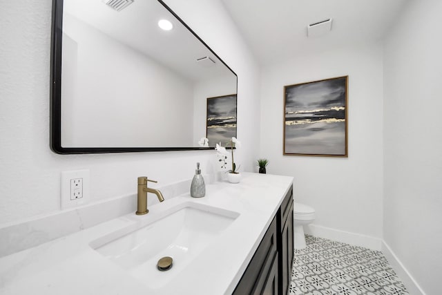 bathroom with tile patterned flooring, vanity, toilet, baseboards, and visible vents