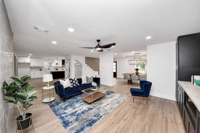 living area featuring light wood-style flooring, stairs, recessed lighting, baseboards, and visible vents