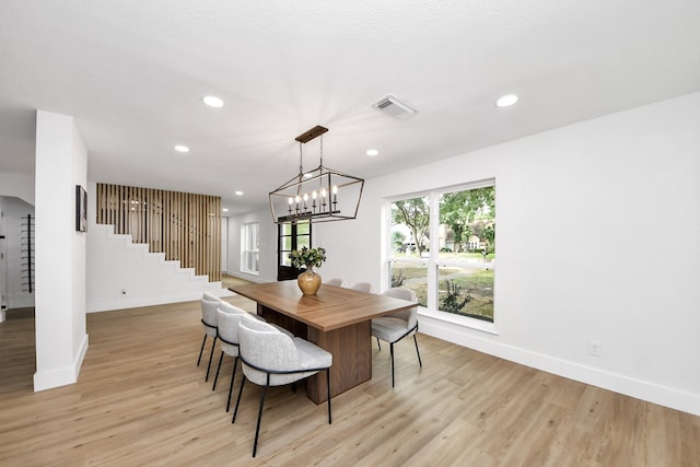dining area featuring baseboards, light wood finished floors, stairs, and visible vents
