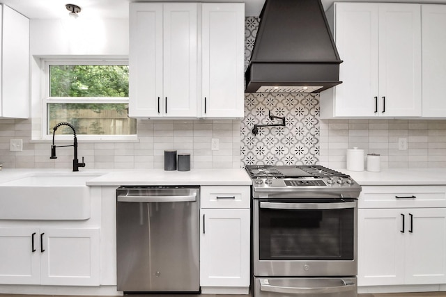kitchen featuring light countertops, stainless steel appliances, a sink, and custom range hood