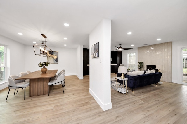 dining room featuring light wood-type flooring, recessed lighting, baseboards, and a healthy amount of sunlight