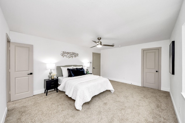 bedroom featuring light colored carpet, a ceiling fan, and baseboards