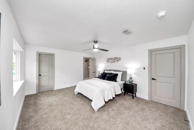 bedroom featuring visible vents, baseboards, ceiling fan, and light carpet