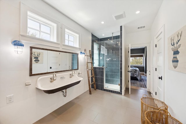 full bathroom featuring a sink, a wealth of natural light, a shower stall, and visible vents