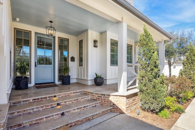 property entrance with covered porch and brick siding