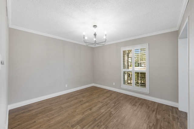 unfurnished room with an inviting chandelier, crown molding, baseboards, and wood finished floors