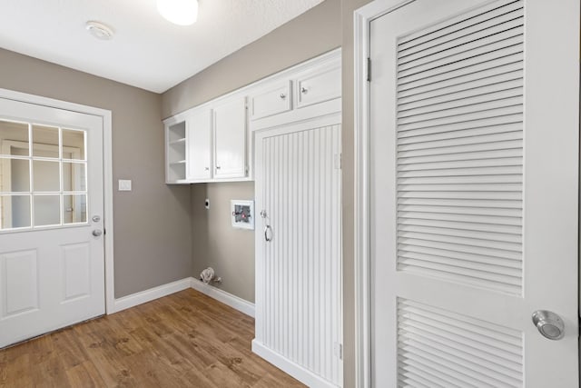 washroom with washer hookup, cabinet space, light wood-style flooring, electric dryer hookup, and baseboards