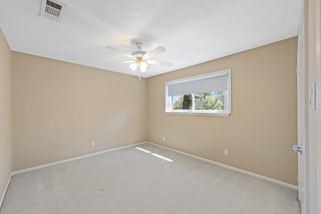 carpeted spare room featuring visible vents, ceiling fan, a textured ceiling, and baseboards