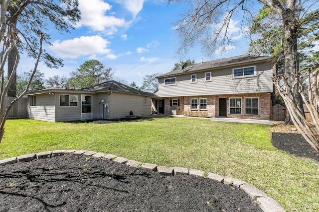 back of property featuring a patio area, brick siding, a yard, and a fenced backyard