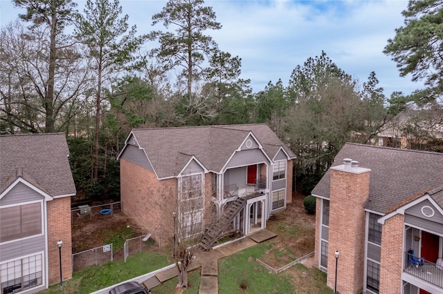 view of front of home with a shingled roof and fence