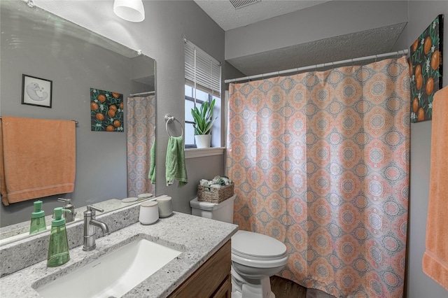 full bath featuring toilet, curtained shower, a textured ceiling, and vanity