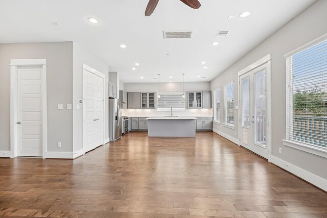 unfurnished living room with dark wood-style floors, baseboards, visible vents, and recessed lighting