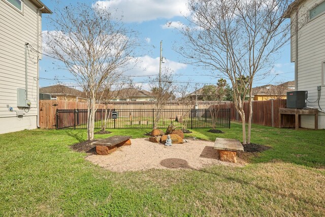 view of yard featuring fence and central AC unit