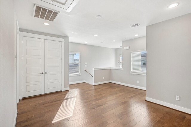 empty room featuring recessed lighting, wood finished floors, visible vents, and baseboards