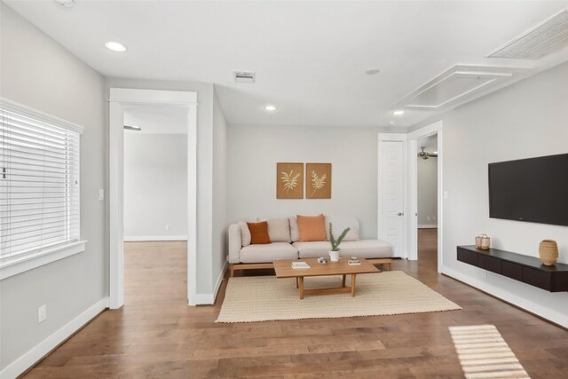 living area with recessed lighting, visible vents, baseboards, and wood finished floors