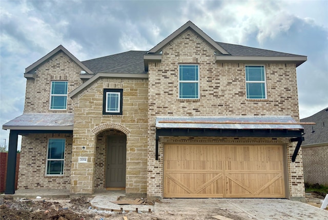 view of front of house featuring concrete driveway, brick siding, an attached garage, and a shingled roof