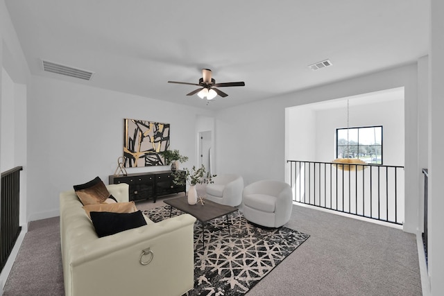 carpeted living room with visible vents and ceiling fan with notable chandelier