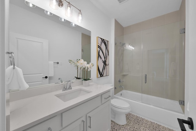 bathroom featuring combined bath / shower with glass door, toilet, vanity, and tile patterned floors